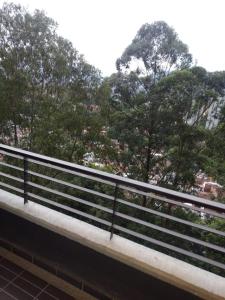 ein Geländer auf einer Brücke mit Bäumen im Hintergrund in der Unterkunft Apartamento de lujo belen medellin. Piscina y gym in Medellín