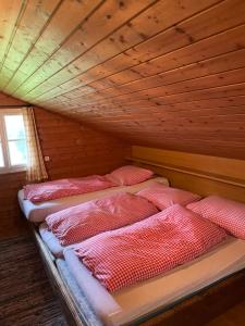 a group of four beds in a wooden room at Ferienhaus Söllhof Krimml in Krimml