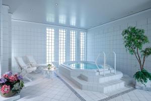 a bathroom with a tub in a room with windows at Romantik Hotel Gebhards in Göttingen