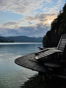 a group of benches sitting on a dock in the water at Wolfgangsee Ferienappartement „Almliebe“ in Strobl
