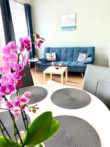 a living room with a table and purple flowers at AZUR Apartments Alsóörs in Alsóörs
