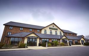 un gran edificio de ladrillo con techo negro en The Wishing Well, en Selby