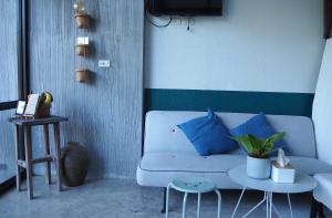 a living room with a couch and two tables at Baan Trok Bedroom Studio Maikhao in Mai Khao Beach