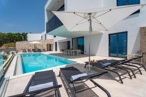 a villa with a swimming pool and patio furniture at Villa Loma, Brzet, Omiš in Omiš
