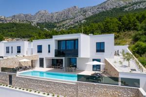 a villa with a swimming pool and mountains in the background at Villa Loma, Brzet, Omiš in Omiš