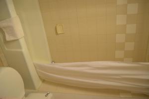 National 9 Inn Gillette في جيليت: حمام مع حوض استحمام ومرحاض