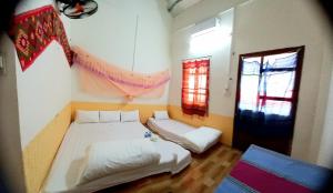 una camera con due letti e una finestra di Mai Tiến Homestay a Mai Châu