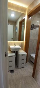 a bathroom with a sink and a mirror and a toilet at SeawaveSunGranCanaria in Telde