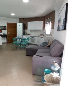 sala de estar con sofá púrpura y cocina en SeawaveSunGranCanaria, en Telde