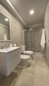 ein Badezimmer mit einem Waschbecken, einem WC und einem Spiegel in der Unterkunft Casa Mate in Salta