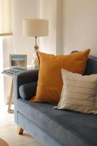 ein blaues Sofa mit Kissen und einen Tisch mit einer Lampe in der Unterkunft Casa Mate in Salta