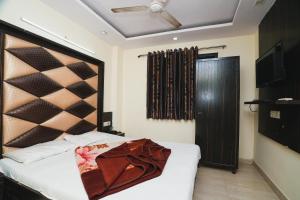 a bedroom with a bed with a wooden headboard at Hotel A V International in New Delhi
