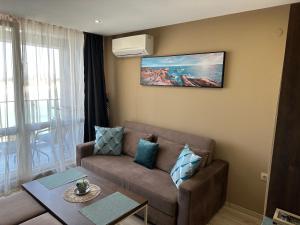 uma sala de estar com um sofá e uma mesa em Sea View Private Studio B 511 em Nessebar