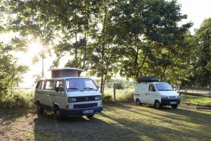 dos vehículos estacionados uno al lado del otro en un campo en Einfachlosmachen-BulliBus, 