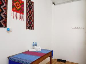 a room with a table and a rug on the wall at Mai Tiến Homestay in Mai Châu