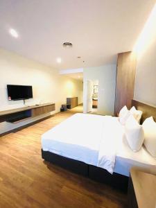 a bedroom with a large white bed and a flat screen tv at Imperial Regency Suites & Hotel Petaling Jaya in Kuala Lumpur