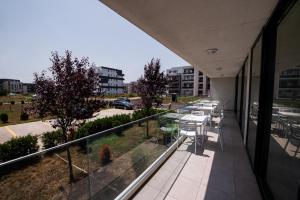 a balcony with tables and chairs on a building at Hotel Clas Mamaia Nord in Mamaia Nord