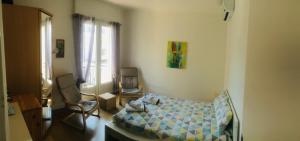 a bedroom with a bed and a chair and a window at Des vacances de rêve in Fréjus