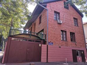 um edifício de tijolos vermelhos com uma varanda em cima de uma garagem em EUROPEAN Backpackers Hostel em Tbilisi