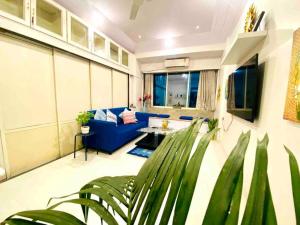 孟買的住宿－Arora Bhavan 1BHK-1B, Khar West by Connekt Homes，客厅配有蓝色的沙发和桌子