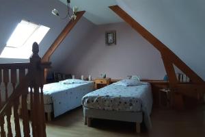 Cette chambre mansardée comprend 2 lits et une fenêtre. dans l'établissement La belmarienne (à 5 min de Montreuil sur Mer), à Beaumerie-Saint-Martin