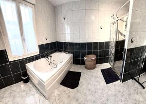 un bagno con vasca, lavandino e doccia di La belmarienne (à 5 min de Montreuil sur Mer) a Beaumerie-Saint-Martin Altre 9 foto