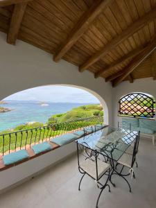 ポルト・チェルボにあるDahu Porto Cervo 3 camere 2 bagni sulla spiaggia cala del faroのダイニングルーム(テーブル付)が備わり、海の景色を望めます。