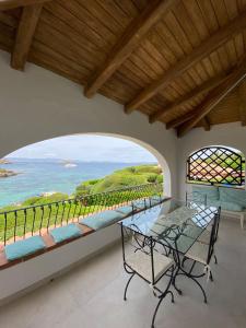 a dining room with a table and a view of the ocean at Dahu Porto Cervo 3 camere 2 bagni sulla spiaggia cala del faro in Porto Cervo