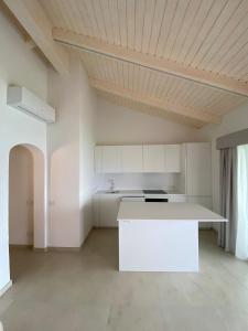 una cocina con una isla blanca en una habitación en Dahu Porto Cervo 3 camere 2 bagni sulla spiaggia cala del faro, en Porto Cervo
