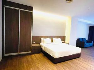 um quarto com uma cama e uma porta de vidro deslizante em Imperial Regency Suites & Hotel Kuala Lumpur em Kuala Lumpur