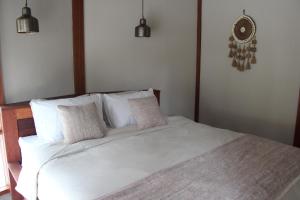 a bedroom with a white bed with two pillows at The Cove Gili Air in Gili Air