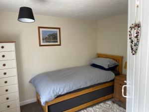 um pequeno quarto com uma cama e uma cómoda em Betty's Cottage - Traditional Norfolk Farm Cottage em Swafield