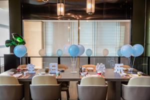 ein Esszimmer mit einem Tisch mit Ballons drauf in der Unterkunft The COLI Hotel Jinan in Jinan