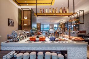 una cucina con buffet di cibi su un bancone di The COLI Hotel Jinan a Jinan