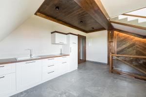 cocina con armarios blancos y techo de madera en Willa Rzoz, en Bukowina Tatrzańska