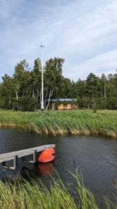 ein Boot neben einem Dock auf einem Fluss in der Unterkunft Trammi Maja 