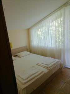 Bett in einem Zimmer mit Fenster in der Unterkunft Hotel Bavaria in Sinemorets