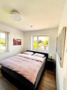1 Schlafzimmer mit einem großen Bett und 2 Fenstern in der Unterkunft Wunderbare Ferienwohnung mit Nähe zum Badesee in Goldenstedt