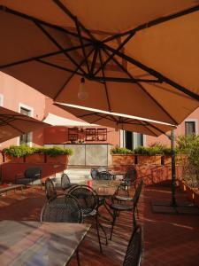 a patio with tables and chairs under an umbrella at Hotel Nuvò in Naples