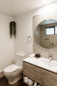 y baño con aseo, lavabo y espejo. en Invercauld House, en Goonellabah
