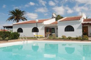 una villa con piscina di fronte a una casa di Maspalomas Suites a Maspalomas