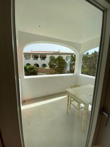a view of a room with a table and a window at Dahu Porto Cervo 3 camere 2 bagni sulla spiaggia cala del faro in Porto Cervo