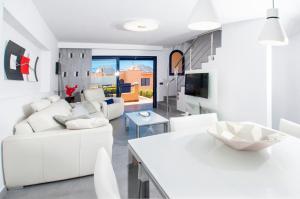un soggiorno con mobili bianchi e tavolo bianco di Meloneras Bay Suites a Meloneras