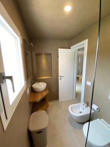 La salle de bains est pourvue de toilettes, d'un lavabo et d'un miroir. dans l'établissement Dahu Porto Cervo 2 camere 2 bagni sulla spiaggia, à Porto Cervo