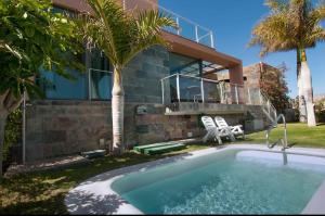 una casa con piscina frente a una casa en Salobre Villas, en Salobre