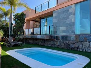 a swimming pool in front of a house at Salobre Villas in Salobre