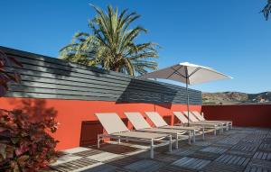 a row of chairs and an umbrella on a patio at Salobre Golf Villas Premium in Salobre