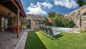 サロブレにあるSalobre Villas Deluxe XLの椅子とスイミングプール付きの庭
