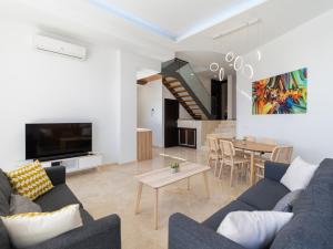 Una sala de estar con un sofá y un comedor. en Salobre Villas Green, en Salobre
