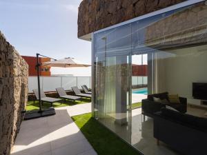 Casa con paredes de cristal y patio en Salobre Villas Green, en Salobre